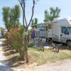 Un camper con biciclette parcheggiato vicino a piante fiorite.