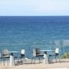 Tavolini e sedie con vista sul mare azzurro.