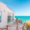 Terrazza sul mare con due persone sedute.