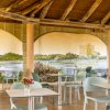 Sala interna con tavoli e murale di paesaggio.
