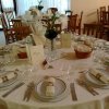 Tavolo rotondo apparecchiato elegantemente per cena.