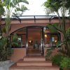 Ingresso di edificio con piante tropicali ai lati.