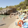 Spiaggia affollata con ombrelloni e bagnanti.