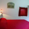 Camera con letto rosso e lampada accesa.