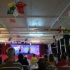 Serata in un locale con palco e pubblico seduto.