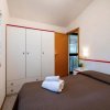 Camera da letto con letto matrimoniale, armadio bianco e finestra con tendine.