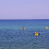 Persone in kayak su un mare calmo e blu.