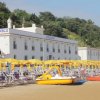 Spiaggia con ombrelloni gialli e hotel sullo sfondo.