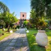 Vialetto in giardino con vasi e alberi.