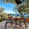 Terrazza con tavolo, sedie e vista mare.
