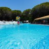Vista della piscina con una decorazione colorata al centro e una tettoia di paglia a destra.